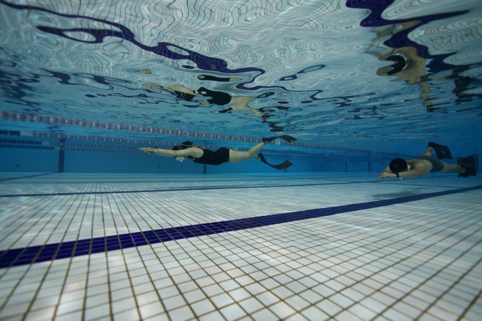 Freediving students training dynamic apnea in the pool